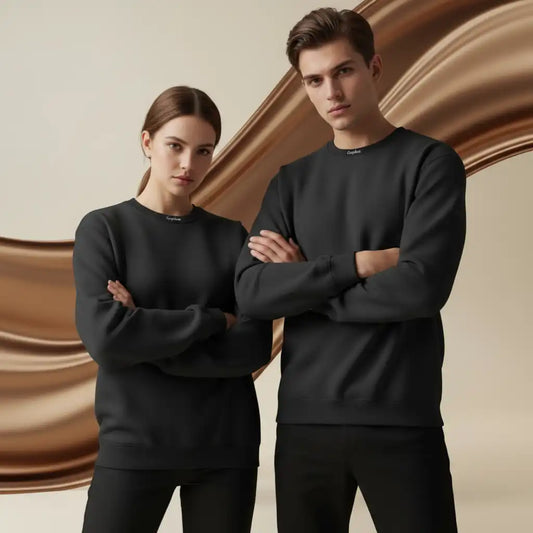 Two people wearing black sweatshirts in front of a brown abstract background